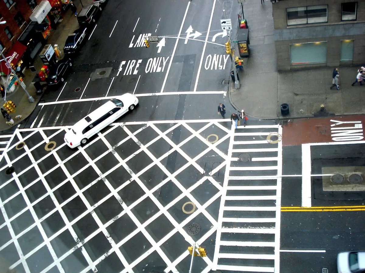 White stretch limousine crossing a New York City intersection, seen from above
